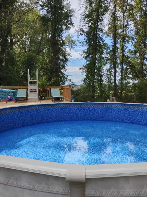Above-ground pool with a new liner beside a deck and ladder