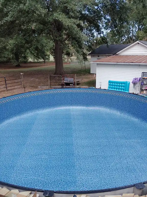 Finished above-ground pool full of water in a back yard