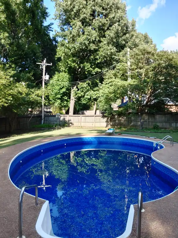 Kidney inground pool with a new liner and handrail