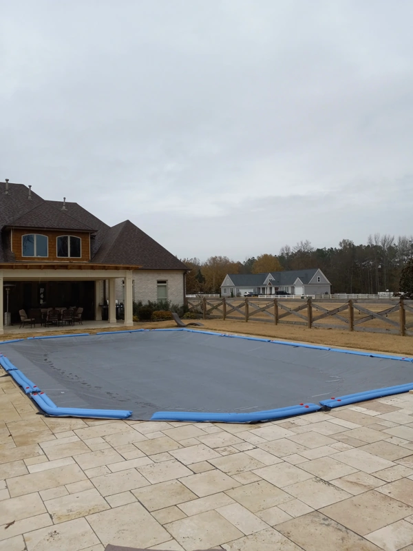 Rectangular inground pool closed under a solid winter cover